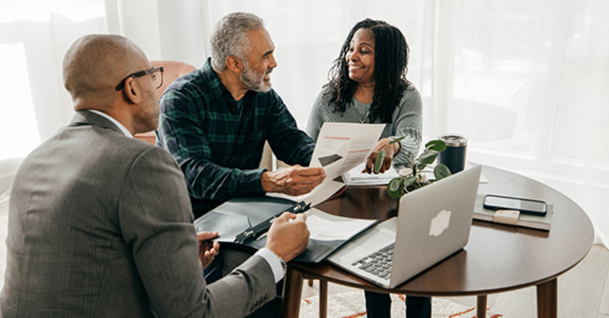 Agent with couple discussing real estate